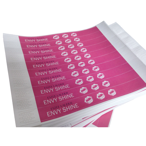Stacked sheets of pink custom-printed Tyvek wristbands showing full-colour branding and repeating graphics
