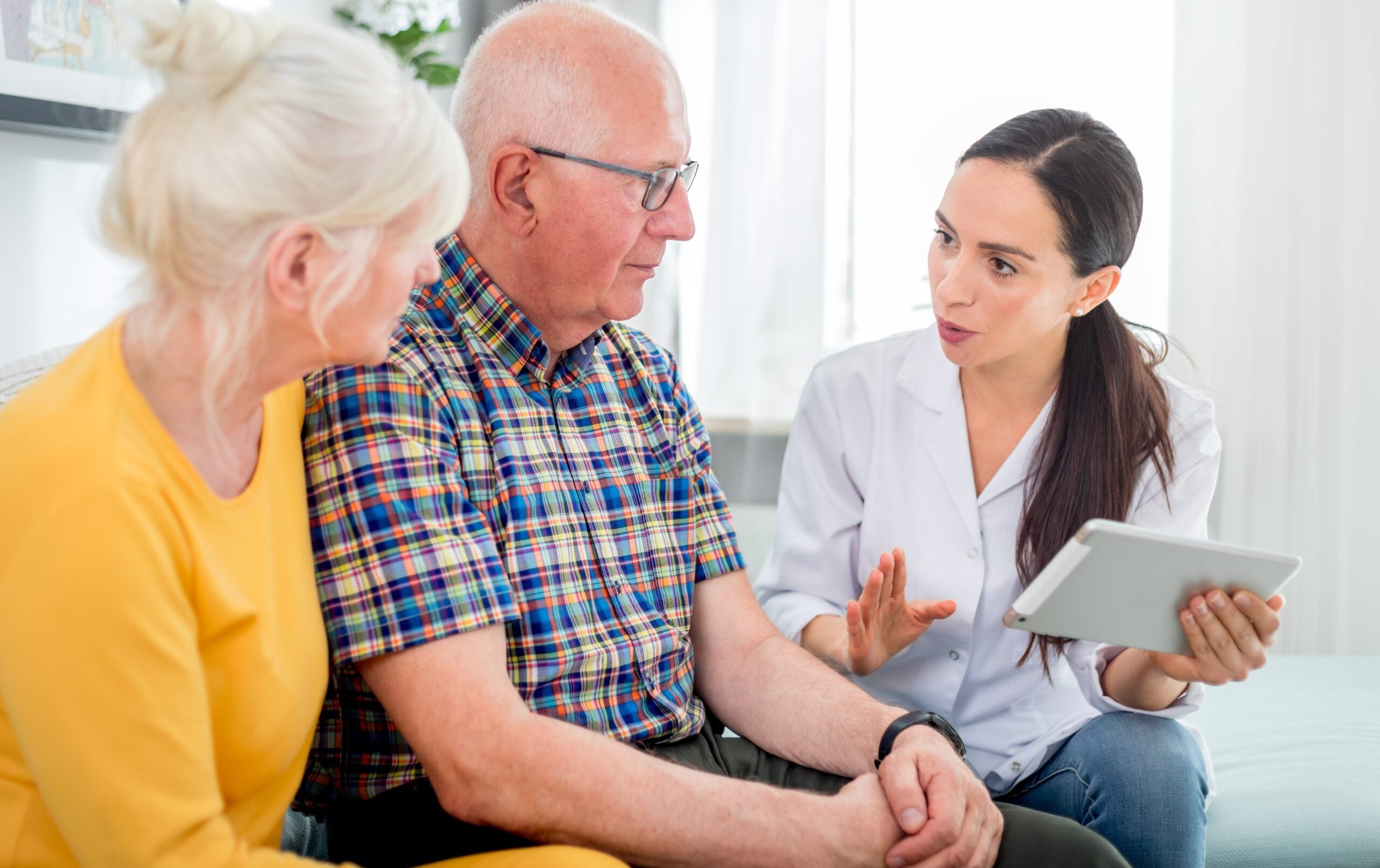 Nurse giving treatment advice to senior couple — dementia hospital communication