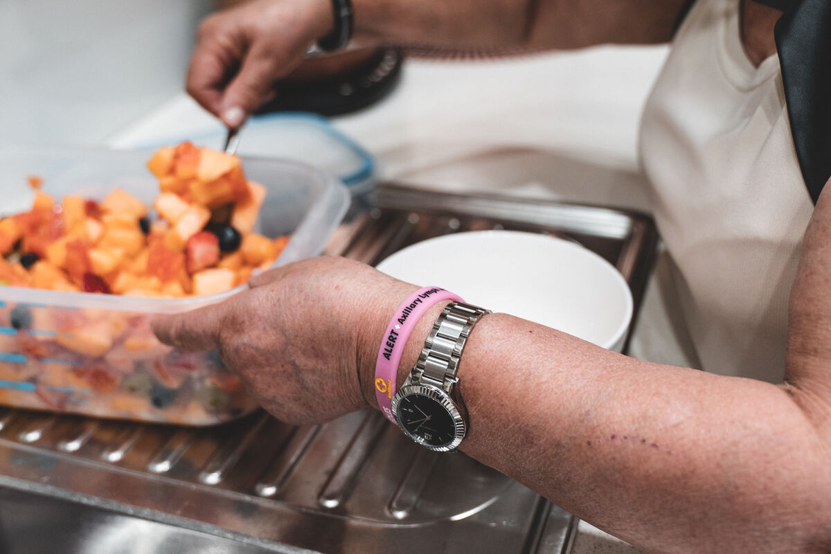 Pink Mediband alert band on a wrist while preparing food