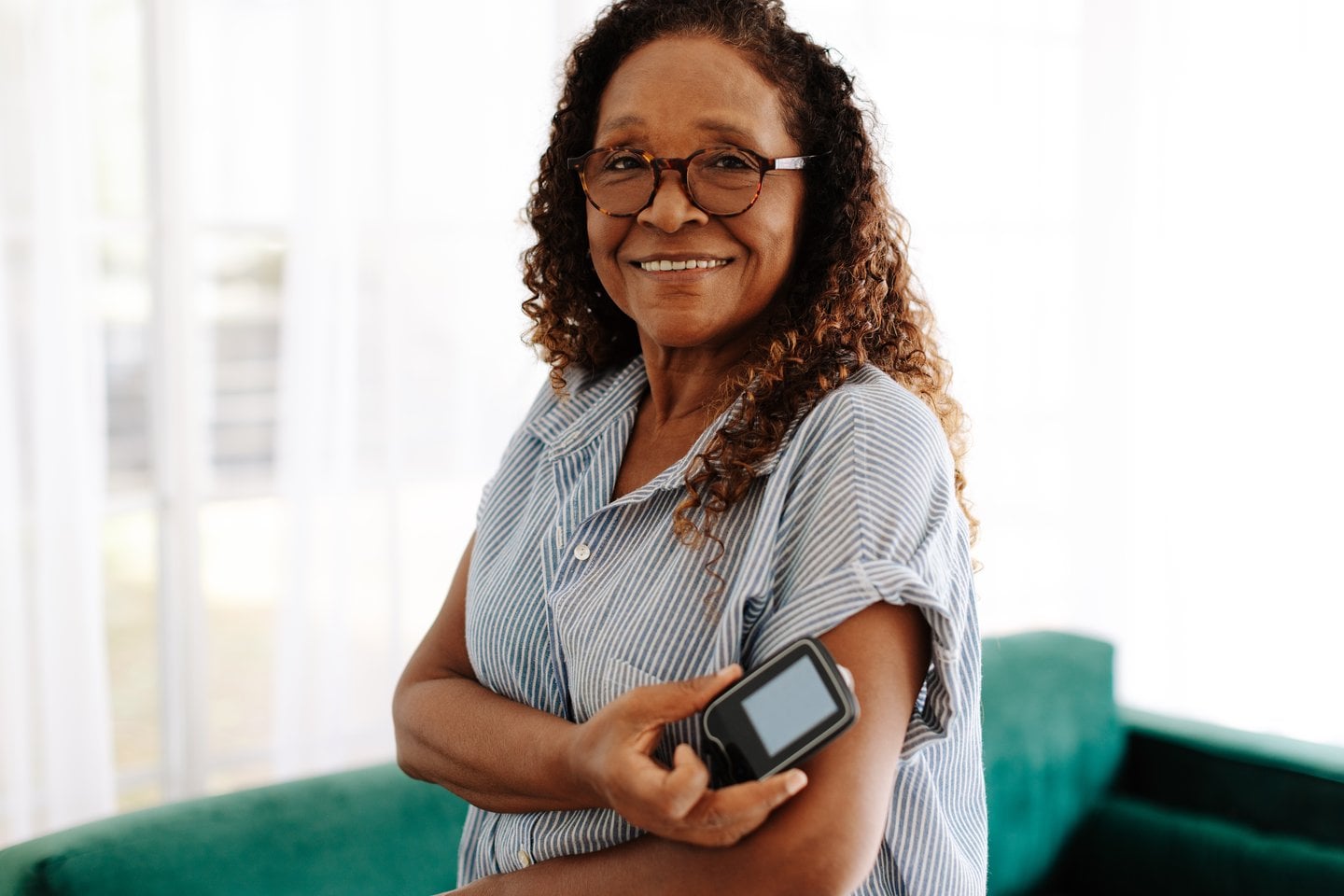 Mature woman with continuous glucose monitor at home — diabetes medical ID bracelet customer