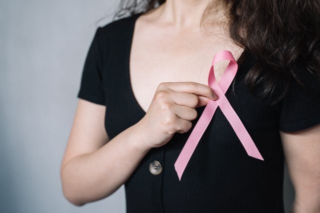 Breast cancer awareness month — pink ribbon and medical alert bracelet for cancer patients